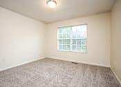 Thumbnail 5 of 17 - A room with a carpeted floor and a window with blinds.