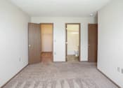 Thumbnail 10 of 26 - A room with a carpeted floor and two doors.
