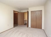Thumbnail 9 of 26 - A room with a carpeted floor and two wooden doors.
