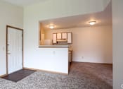 Thumbnail 27 of 30 - Main living area and kitchen of a River Valley apartment home in Lancaster, OH, with carpeting and cabinets.