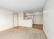 Thumbnail 2 of 30 - Main living area and kitchen of a River Valley apartment home in Lancaster, OH, with carpeting and cabinets.