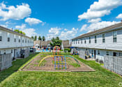 Thumbnail 26 of 30 - A playground with a swing set in the middle of a grassy area at River Valley Apartments in Lancaster, OH.