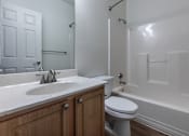 Thumbnail 24 of 27 - A white bathroom with a toilet, sink, and bathtub.