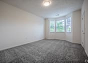 Thumbnail 22 of 27 - A spacious room with a grey carpet and white walls.