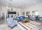 Thumbnail 33 of 36 - A living room with a blue couch and a patterned chair.