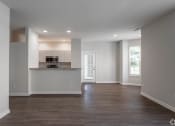 Thumbnail 2 of 27 - an empty living room with a kitchen with a counter and a door