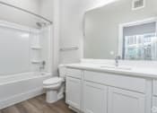 Thumbnail 10 of 53 - A white bathroom with a toilet, sink, and bathtub.