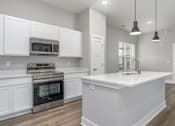Thumbnail 53 of 53 - A modern kitchen with white cabinets and a large island.
