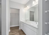 Thumbnail 3 of 53 - A bathroom with a sink, mirror, and wooden floor.