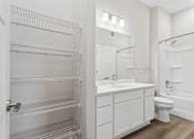 Thumbnail 13 of 71 - Bathroom with quartz countertops, closet, and bath/shower of an apartment unit.