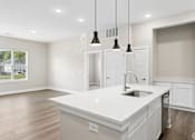 Thumbnail 59 of 71 - Kitchen with appliances and living area of an apartment home at Tiffany Flats in Columbus, OH.