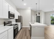 Thumbnail 58 of 71 - Kitchen with appliances and living area of an apartment home at Tiffany Flats in Columbus, OH.