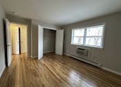 Thumbnail 6 of 9 - A room with wooden floors and a window.