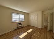 Thumbnail 4 of 12 - A room with wooden floors and a window with blinds.