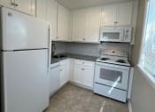 Thumbnail 6 of 21 - a kitchen with white appliances and white cabinets
