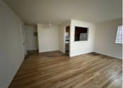 Thumbnail 6 of 12 - A room with wooden flooring and a window.