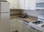 Thumbnail 1 of 12 - A kitchen with white cabinets and appliances.