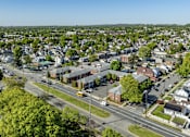 Thumbnail 13 of 13 - A small town with a lot of greenery and a clear sky.