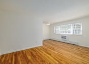 Thumbnail 9 of 13 - A room with wooden floors and a window with blinds.