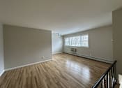 Thumbnail 9 of 9 - A room with wooden floors and a window with blinds.