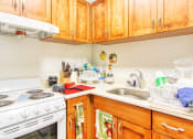 Thumbnail 8 of 13 - kitchen with white appliances and wood cabinets