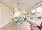 Thumbnail 11 of 12 - Patio with tables, chairs, and ceiling fans at Holy Cross Manor I