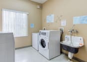 Thumbnail 10 of 12 - Laundry room with washers, dryers, and laundry sink