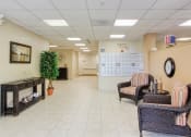 Thumbnail 4 of 12 - Lobby with chairs, clock, decor, and resident malbox bank
