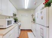 Thumbnail 6 of 12 - kitchen with white cabinets and appliances at Holy Cross Manor I