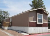 Thumbnail 4 of 13 - a house with brown siding and a white picket fence