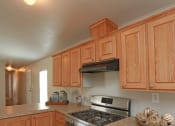 Thumbnail 18 of 18 - a kitchen with wooden cabinets and a stove top oven