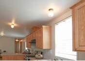 Thumbnail 17 of 18 - a kitchen with wooden cabinets and a large window