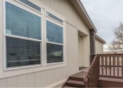 Thumbnail 8 of 18 - a home with a wooden deck and a tree in the background
