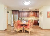 Thumbnail 10 of 22 - community kitchen with table, chairs, fridge, cabinetry, and track lighting