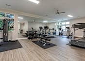 Thumbnail 6 of 18 - Spacious fitness center with cardio machines and weights at The Apartments at The Sycamores, Virginia