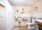 Thumbnail 8 of 12 - bathroom with handrails, tile, and low entry shower