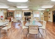 Thumbnail 9 of 24 - Community room with long tables and chairs at Casa San Pablo