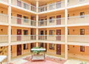 Thumbnail 21 of 24 - balconies with residential doors looking out over courtyard patio