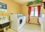 Thumbnail 18 of 24 - community laundry room with washers, dryers, and laundry sink