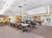 Thumbnail 3 of 30 - large community room with tables, chairs, and piano