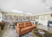 Thumbnail 6 of 30 - library with comfortable seating, many shelves of books, and large reading table