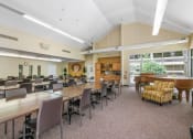 Thumbnail 4 of 30 - community room with rows of tables and chairs and a piano at Sundale Manor Apartments