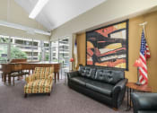 Thumbnail 5 of 30 - community room with large painting, couch, chairs, American flag, and piano