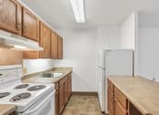 Thumbnail 14 of 30 - kitchen with stove, fridge, ample wood cabinets, bar, and overhead lighting
