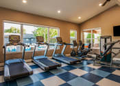 Thumbnail 18 of 26 - a gym with cardio equipment and a large window with a view of the pool