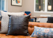 Thumbnail 14 of 26 - a leather couch with pillows and a coffee table in the background
