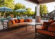 Thumbnail 9 of 26 - a patio with couches and umbrellas