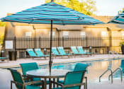 Thumbnail 8 of 26 - a pool with a table and chairs next to it
