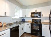 Thumbnail 22 of 26 - a kitchen with white cabinets and black appliances
