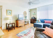 Thumbnail 8 of 17 - spacious living room with large window, wood-style flooring, and ceiling fan